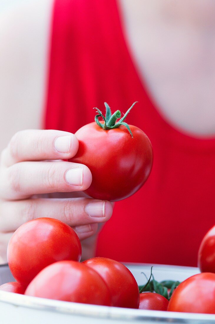 A woman holding a tomato