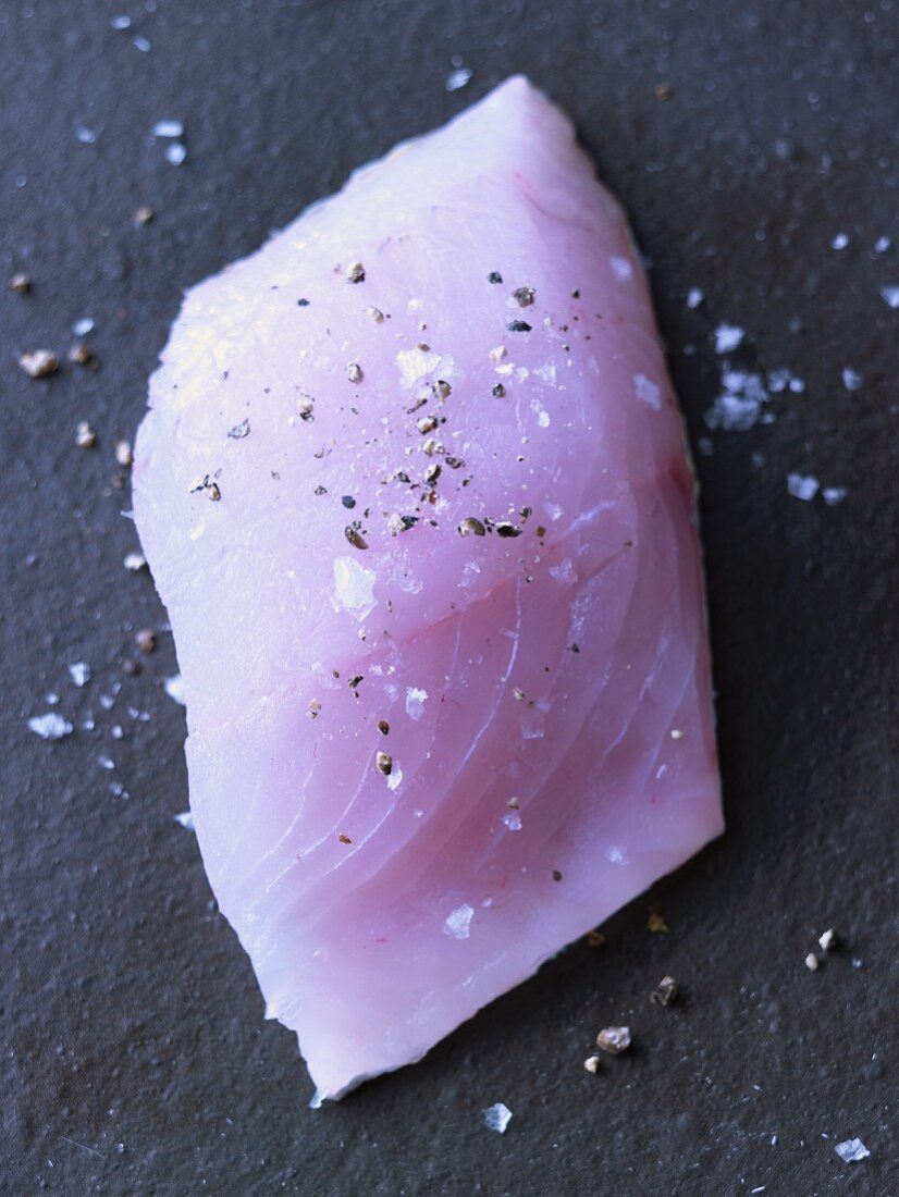 Zander fillet being seasoned with sea salt and pepper