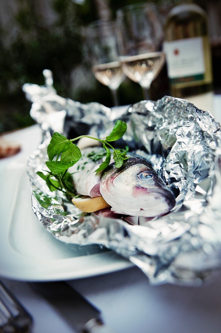 Trout wrapped in aluminium foil with lemon and basil