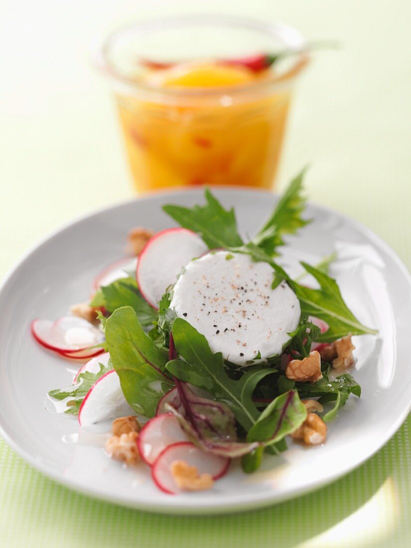 Sommersalat mit Ziegenkäse und Walnüssen; im Hintergrund Aprikosenchutney mit Chili