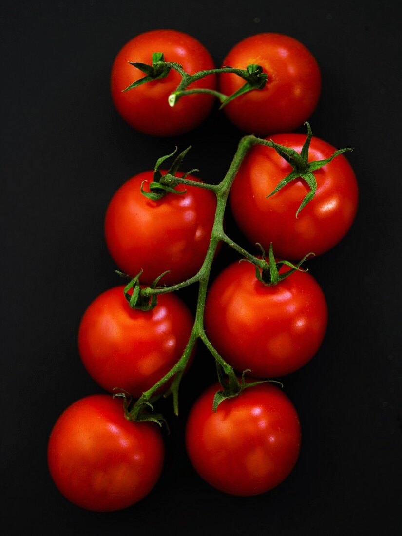 Vine tomatoes on a black surface