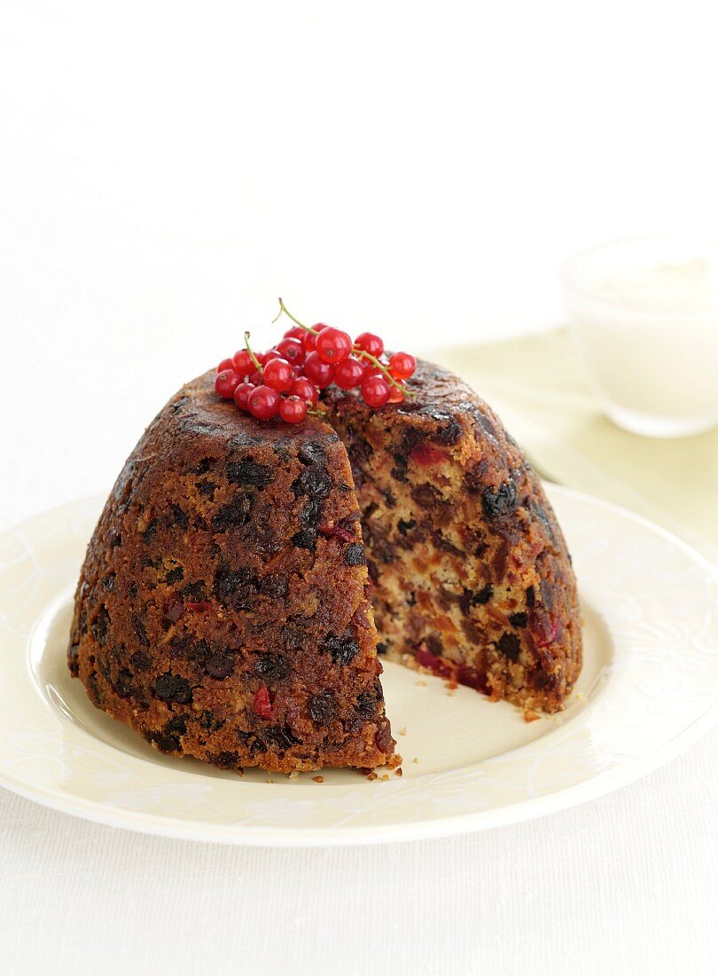 Christmas puddings with redcurrants, sliced