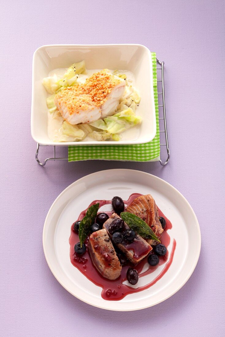 Wolffish fillet with an almond crust on pointed cabbage and tuna with olives and blueberries in red wine sauce