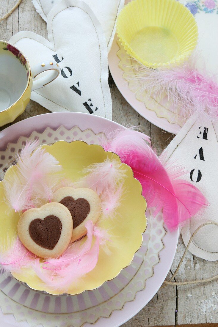 Table decoration with heart-shaped biscuits, feathers and hand-sewn fabric hearts