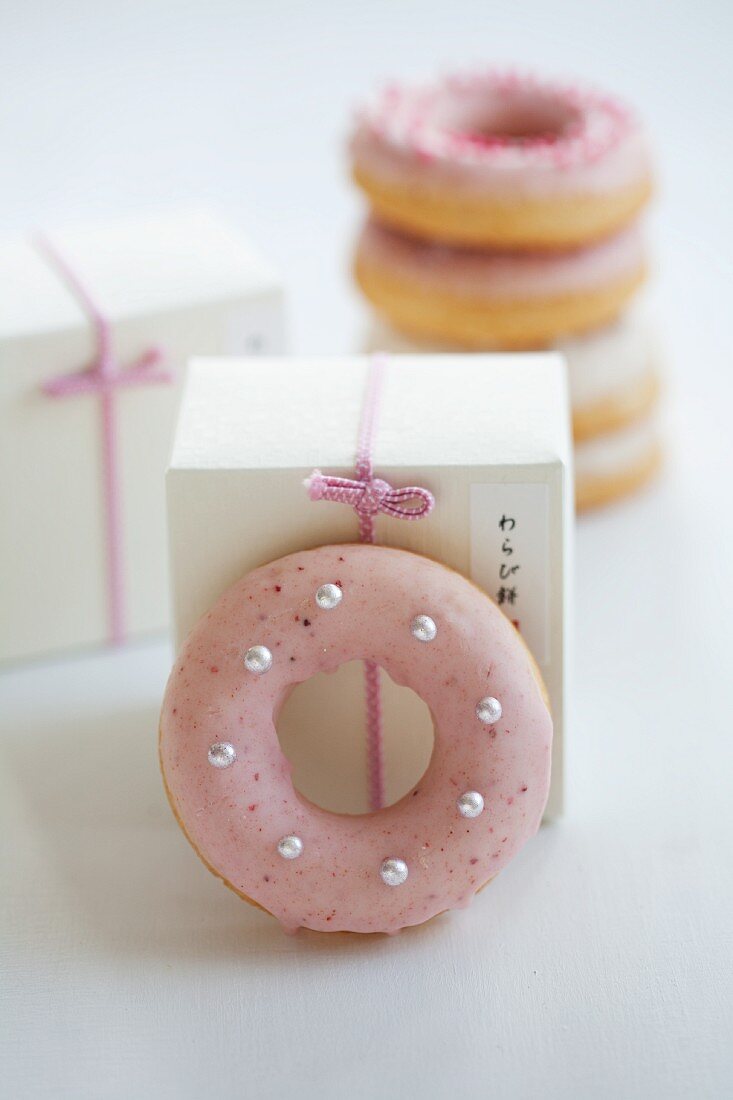 Doughnuts mit rosa und weißem Zuckerguss zum Verschenken