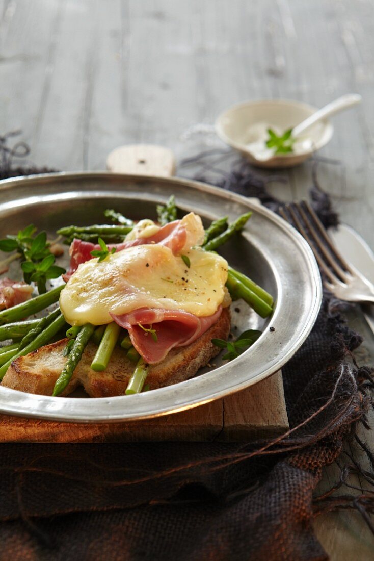 Toasted bread with green asparagus, ham and cheese