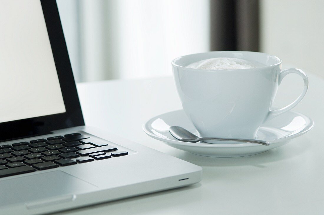 Cappuccino next to a laptop