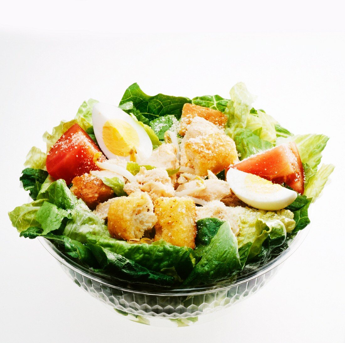 Fast Food Chicken Caesar Salad in a Plastic Container; White Bowl