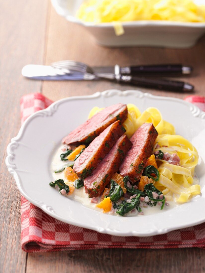 Duck breast with oranges, spinach and tagliatelle