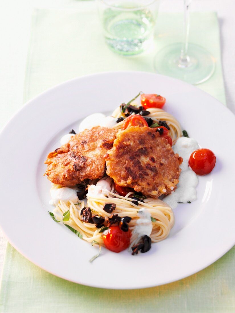 Piccata with spaghetti, tomatoes and olives