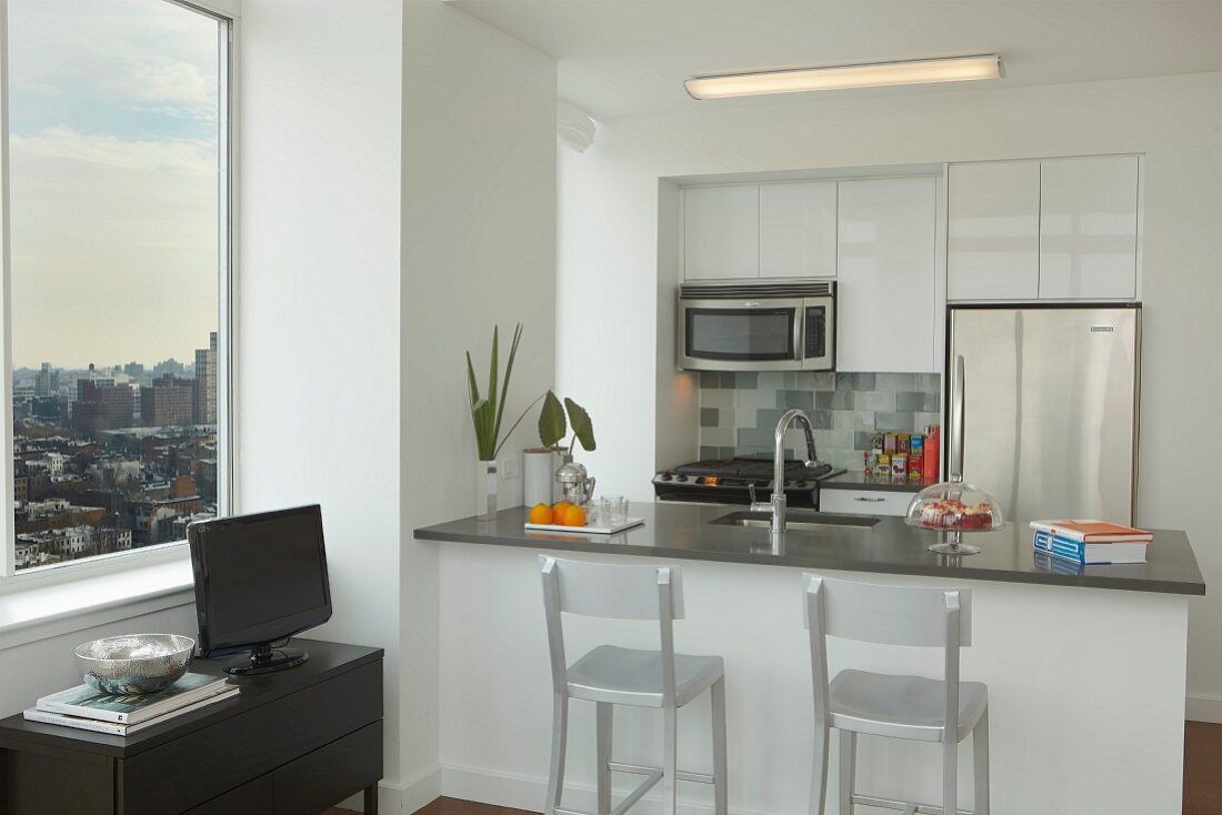 Offene Miniküche mit separater Frühstückstheke im Wohnbereich mit Blick über die Skyline