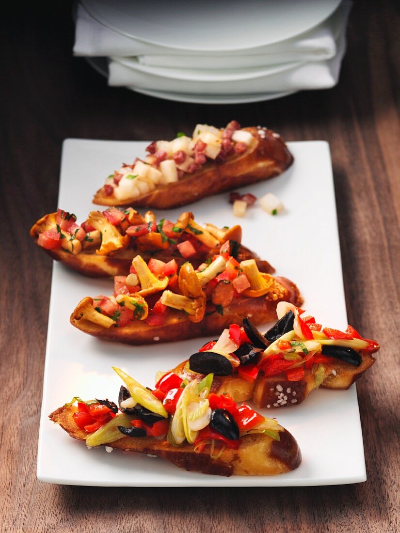 Crostini topped with chanterelle mushrooms, tomatoes and olives