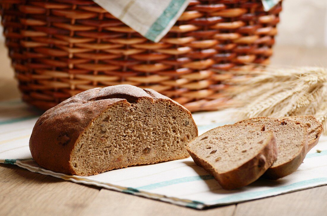 Country bread, sliced, ears of wheat and a basket