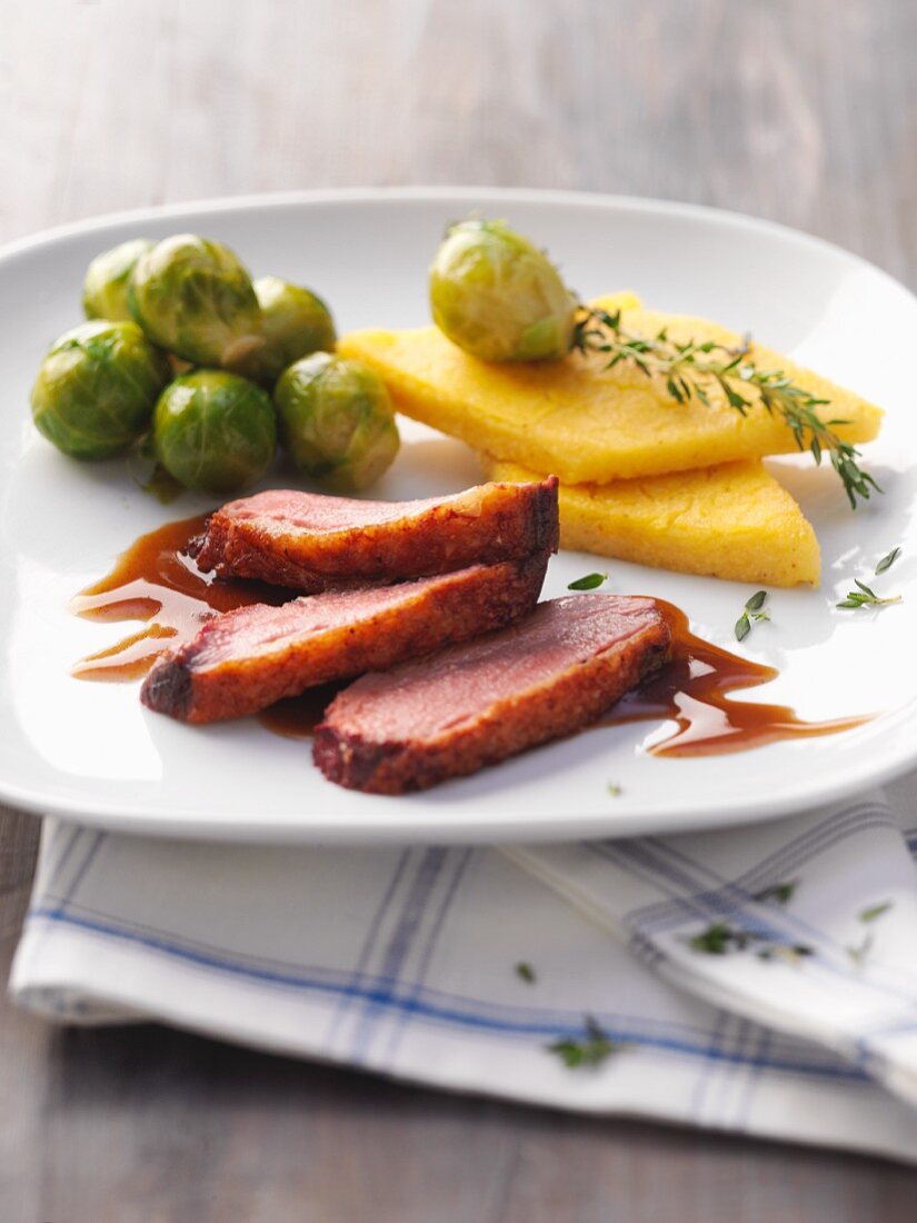Duck breast with polenta slices and Brussels sprouts