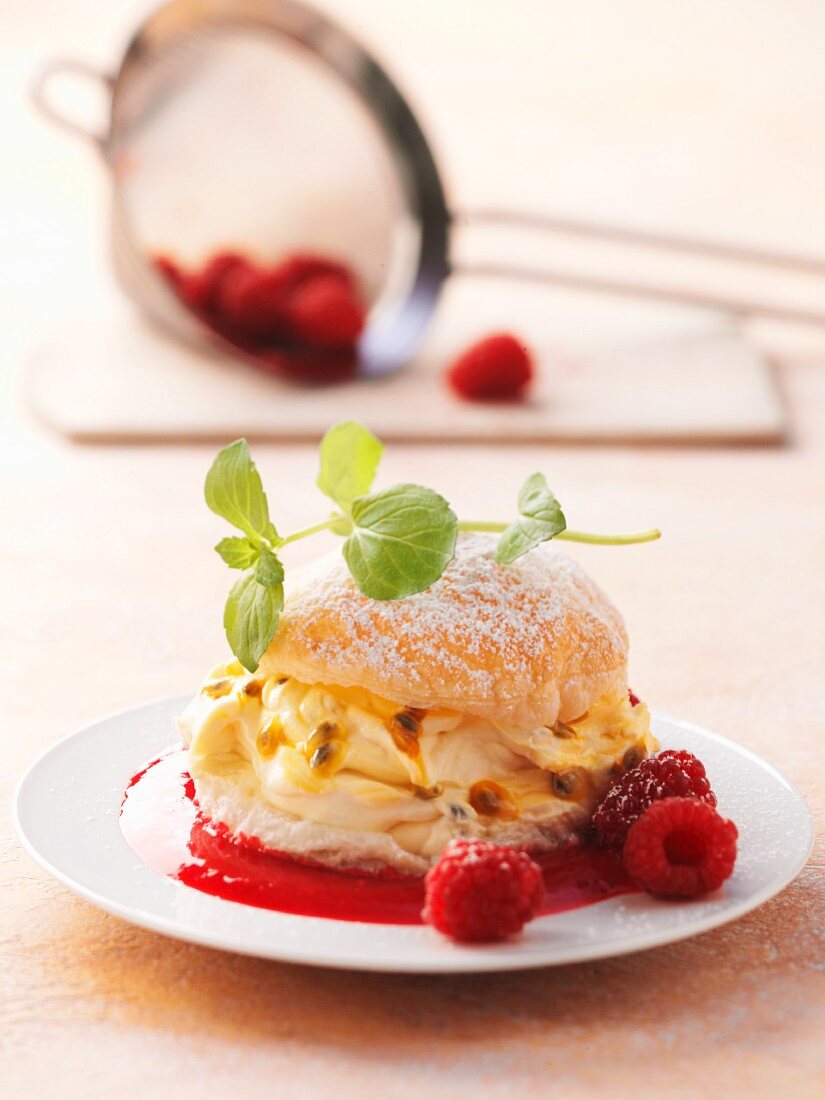 A brioche filled with mascarpone and passion fruit cream with raspberry sauce