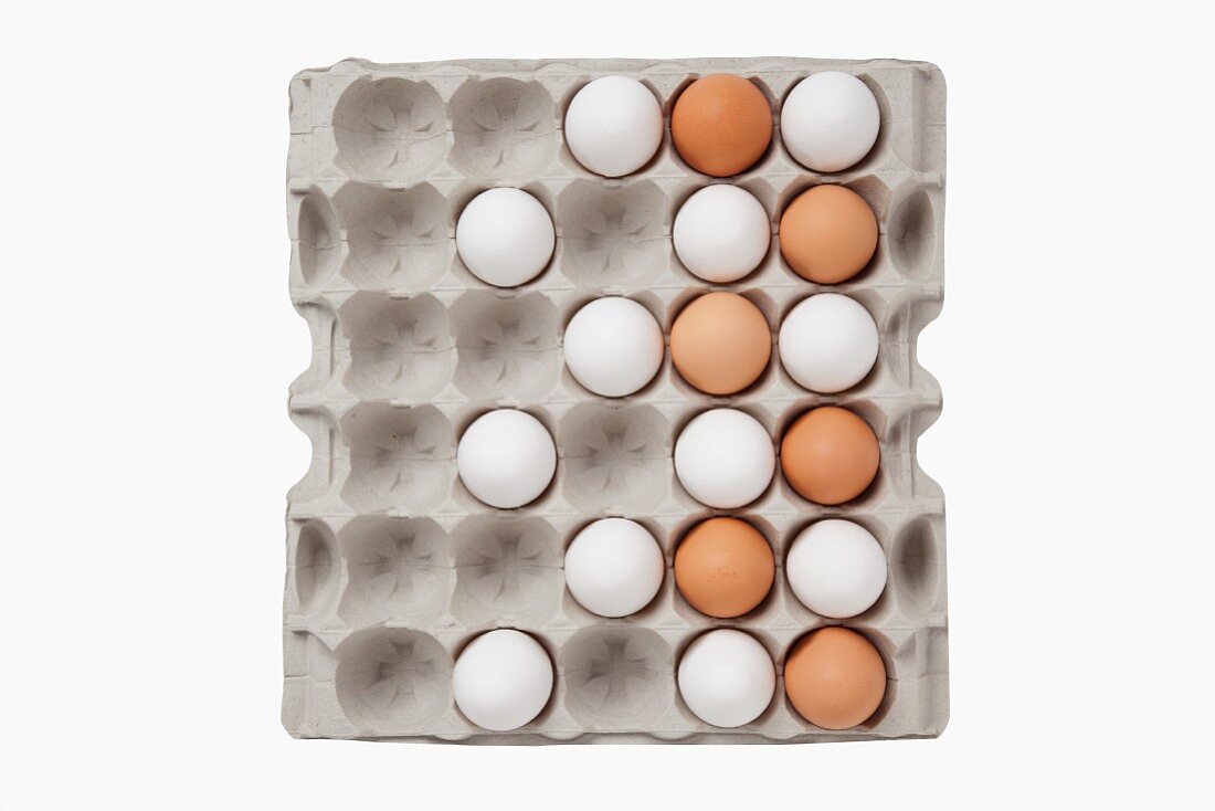 White and brown eggs in an egg box