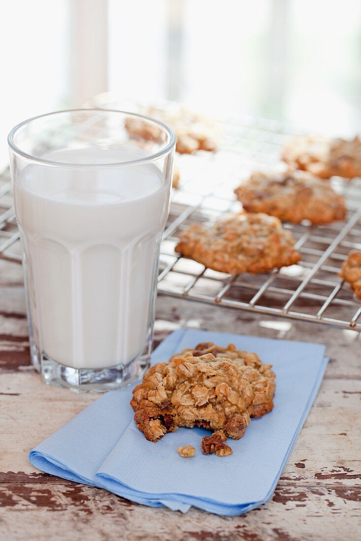 Homemade Oatmeal Cookies with a Glass of Milk; One Cookie with Bite Taken Out; Cookies on Cooling Rack