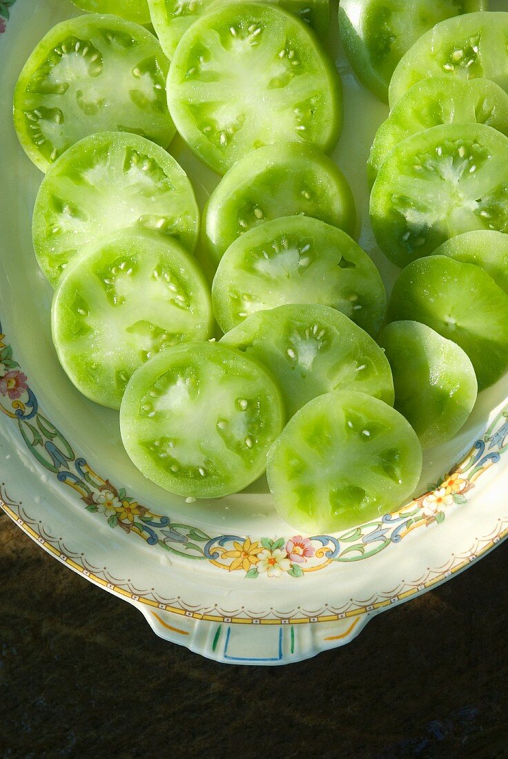 Grüne Tomaten in Scheiben geschnitten auf Teller