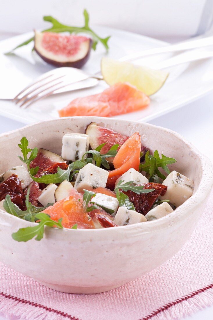 A rocket, salmon, fig, dried tomatoes and blue cheese salad