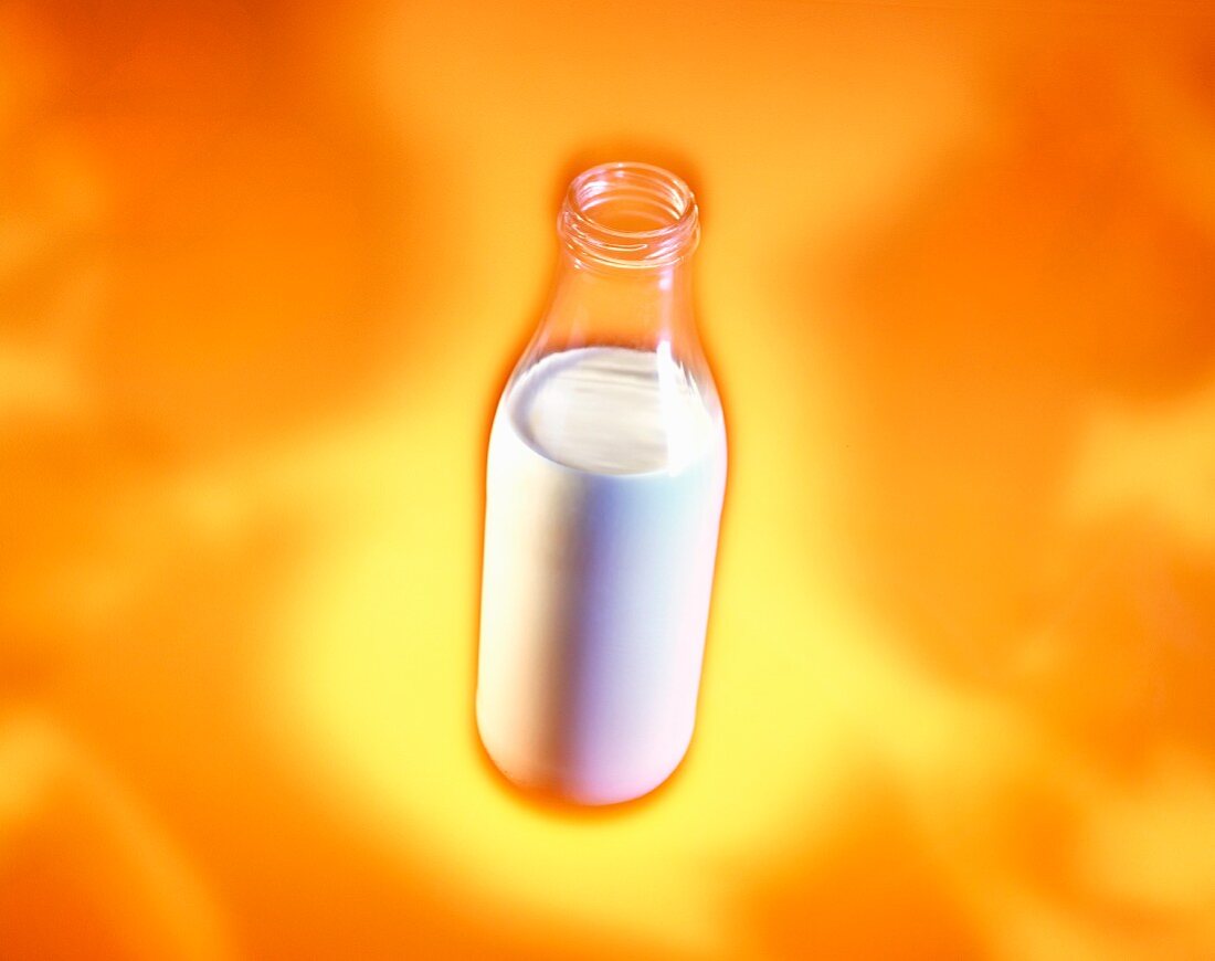 Eine Milchflasche auf orangefarbener Untergrund