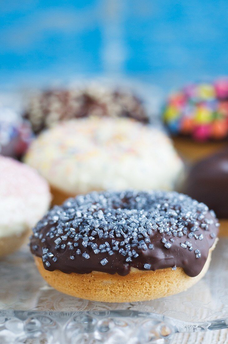 Gebackene Doughnuts mit dunkler und weisser Schokoglasur und Zucker