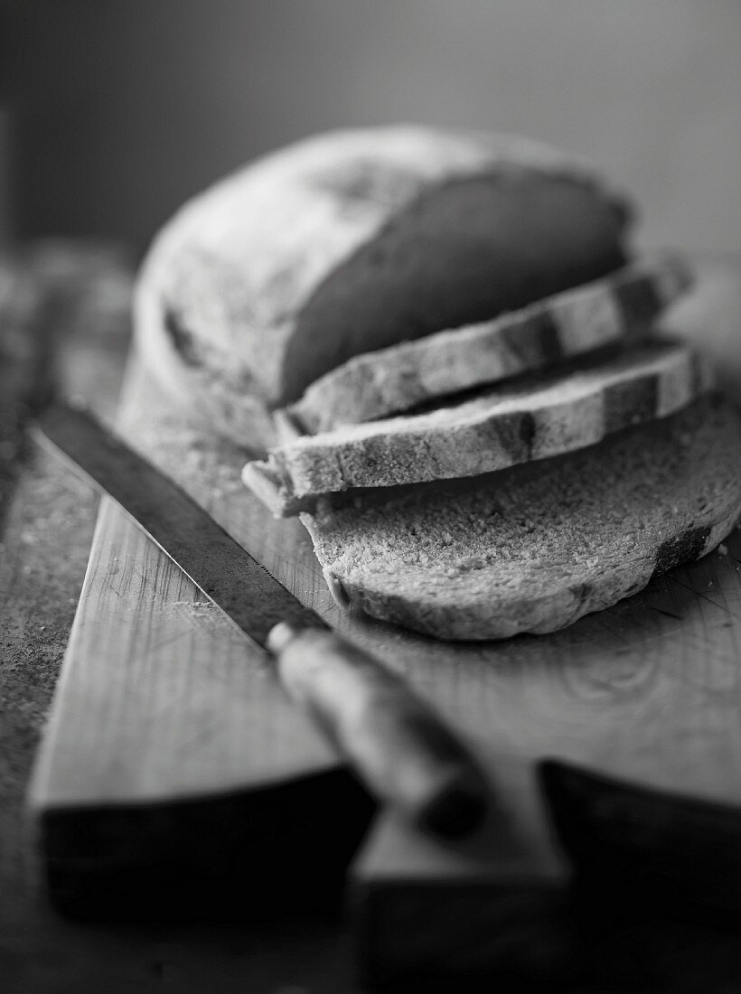 Bread, partly cut into slices (black and white image)