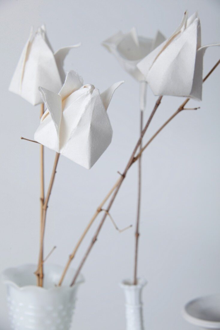White paper flowers on twigs as a table decoration