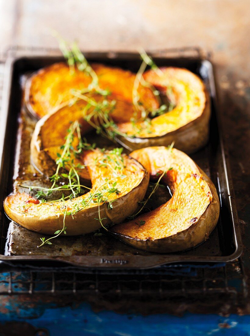 Roasted squash wedges on a baking tray