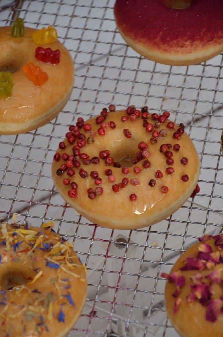 Doughnuts with various toppings on a wire rack