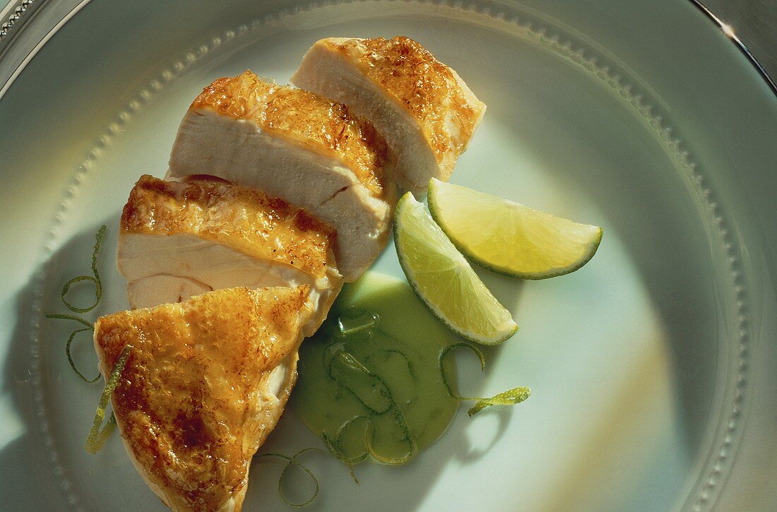 Sliced chicken breast with lime wedges