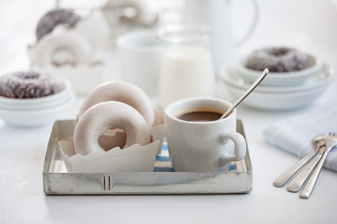 Doughnuts und eine Tasse Kaffee auf einem Tablett