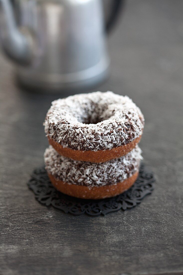 Two doughnuts with chocolate glaze and grated coconut