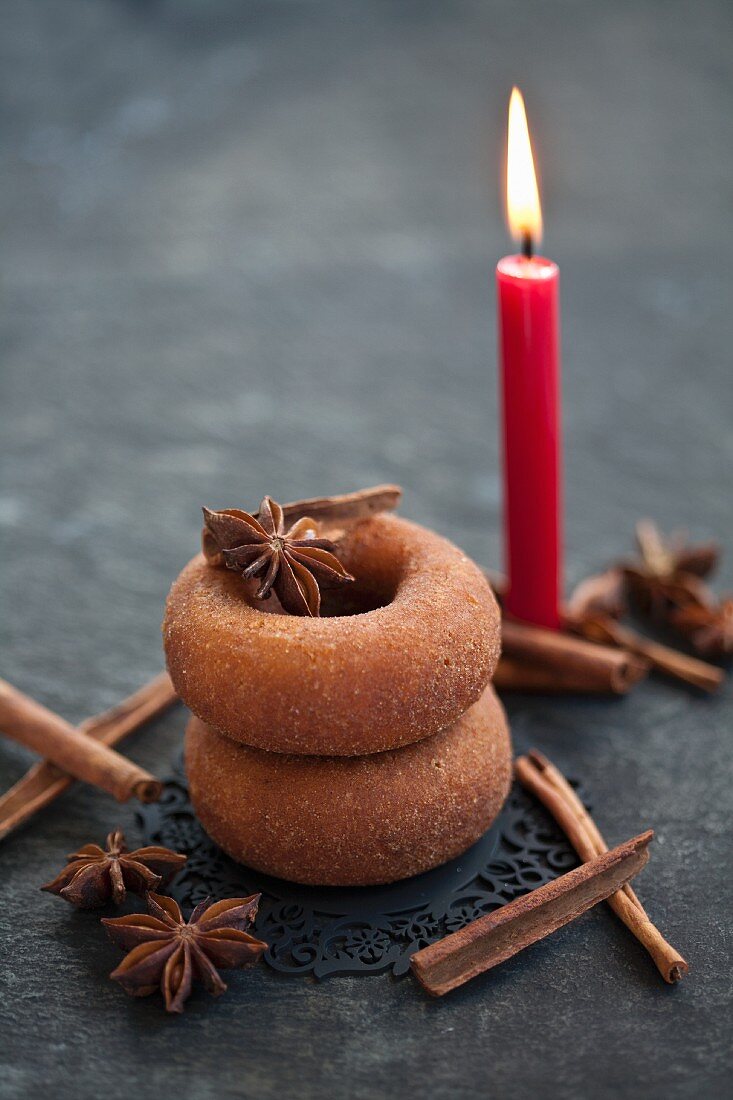 Doughnuts mit Zimt und Sternanis und eine Kerze