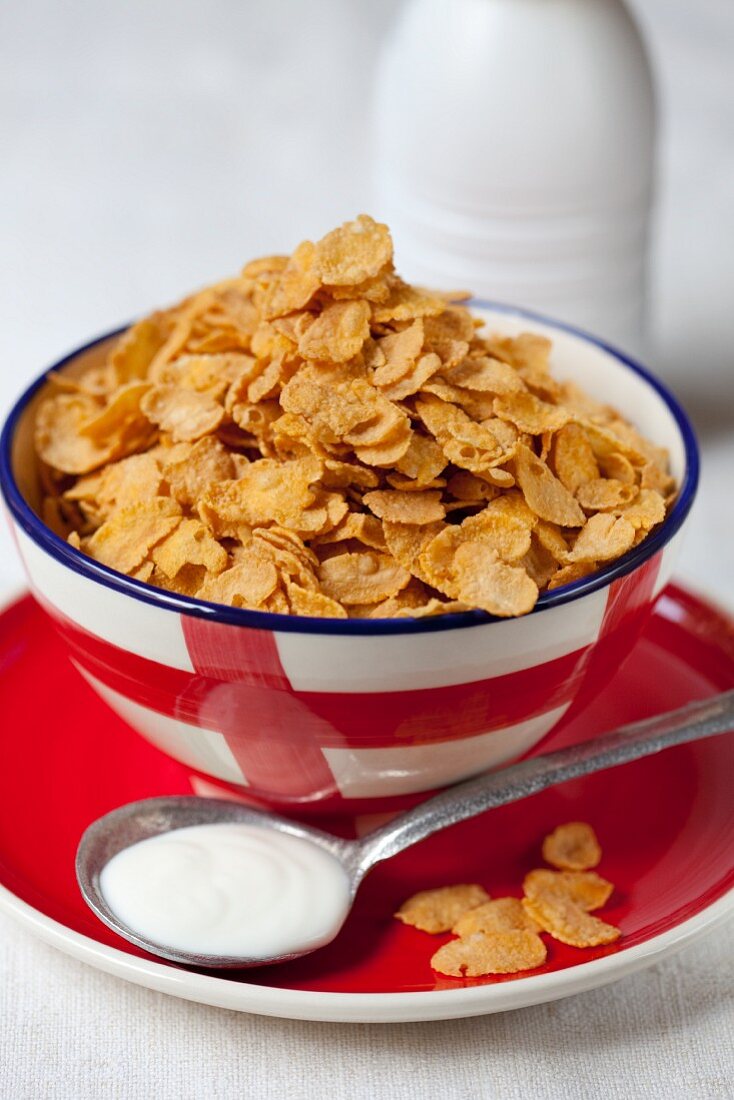 A bowl of cornflakes with a spoonful of yogurt