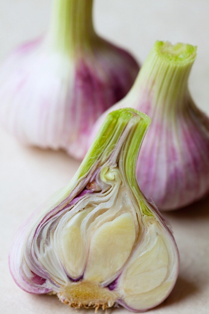 Three fresh garlic bulbs, whole and halved