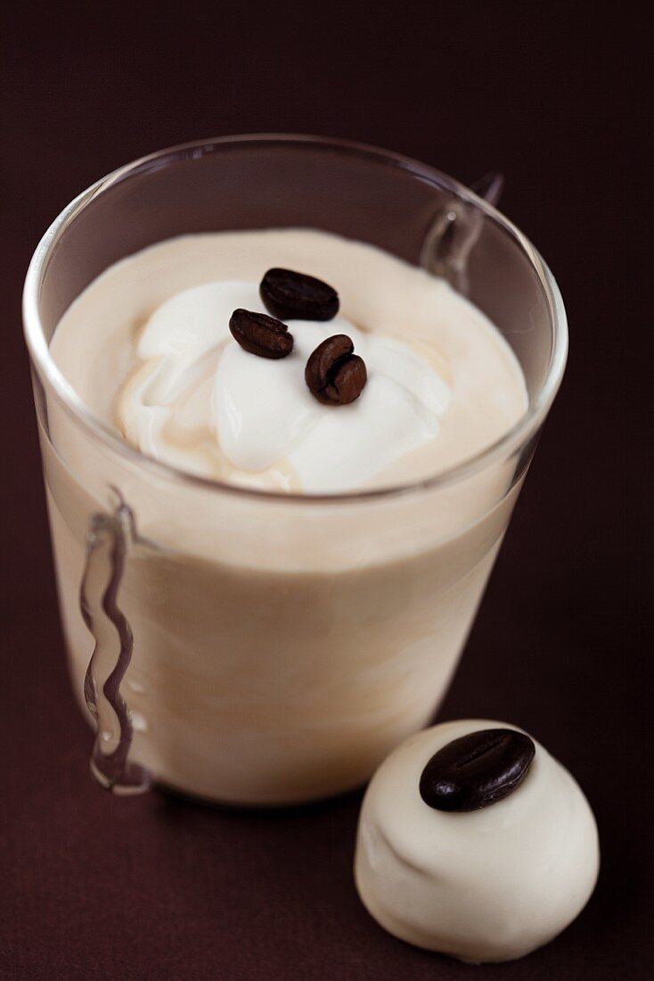 Mocha cream with whipped cream, coffee beans and a praline