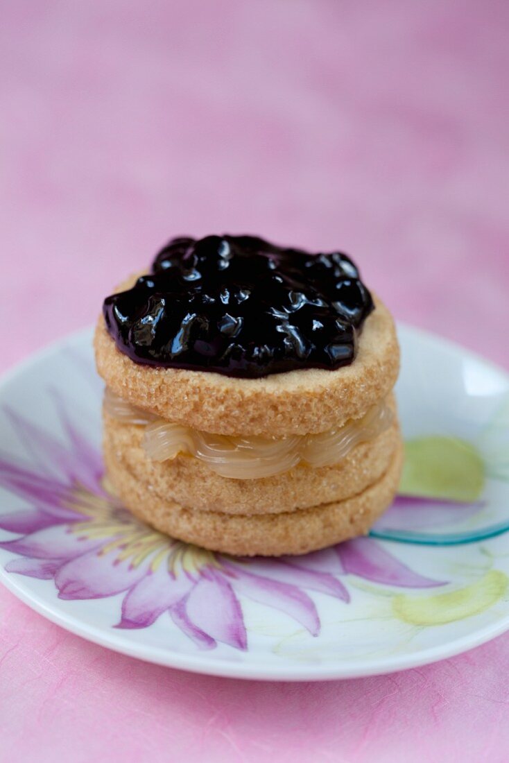 A shortbread petit four filled with lemon curd and blueberry jam