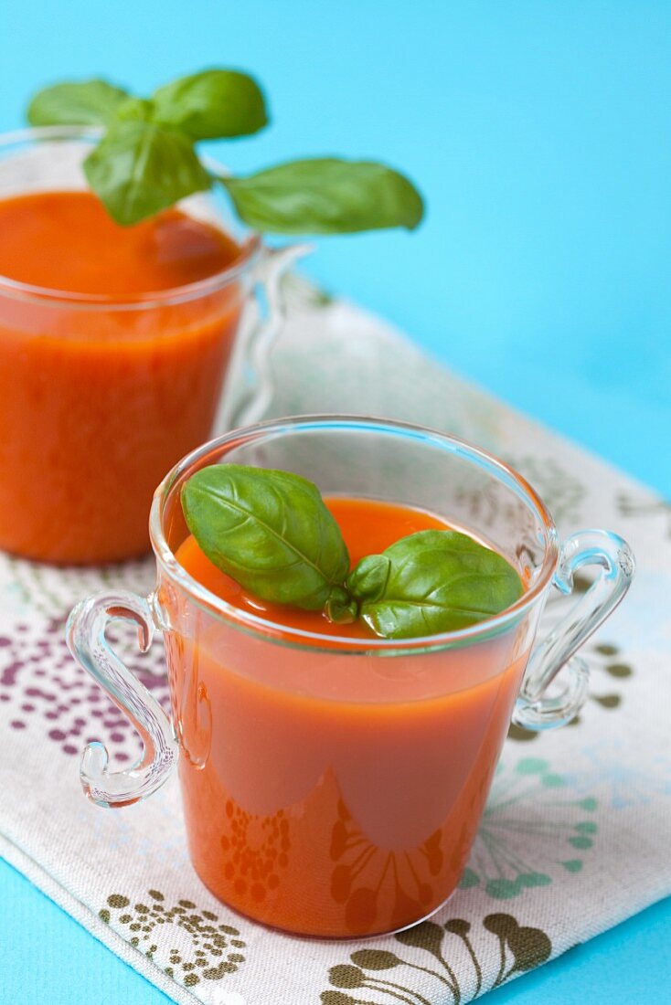 Tomato soup with basil in glass cups