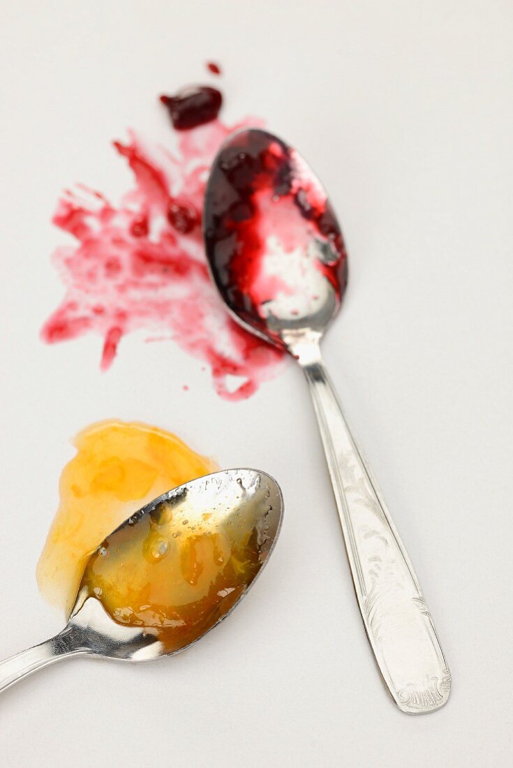 Apricot jam and cherry jam on spoons