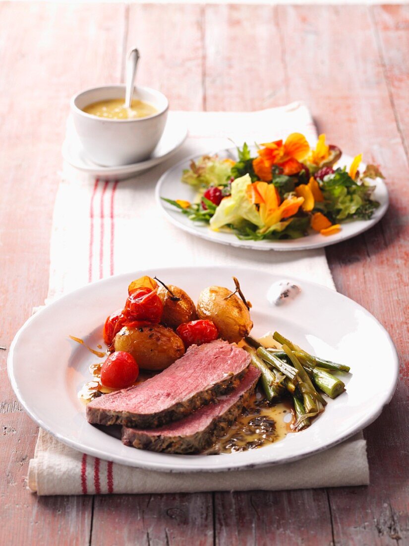 Roast beef with a potato and tomato ragout and a spring salad