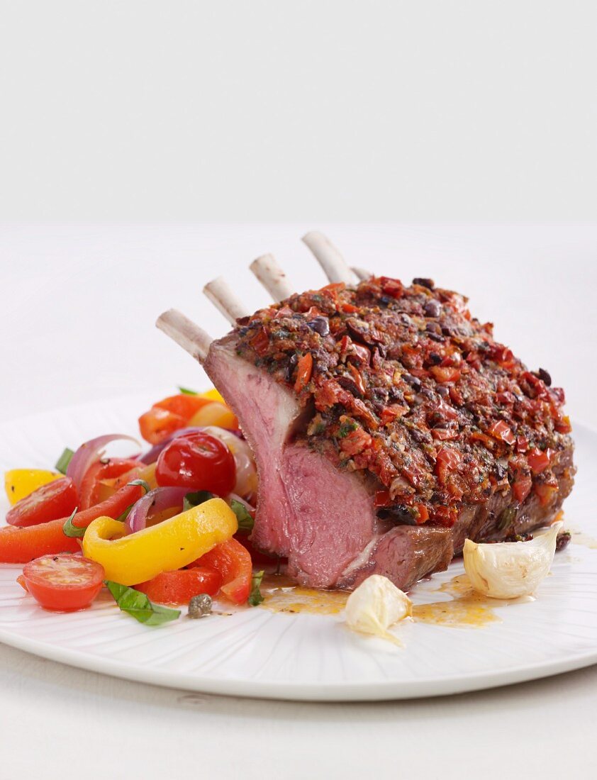 Rack of lamb with a tomato and olive crust and a pepper medley