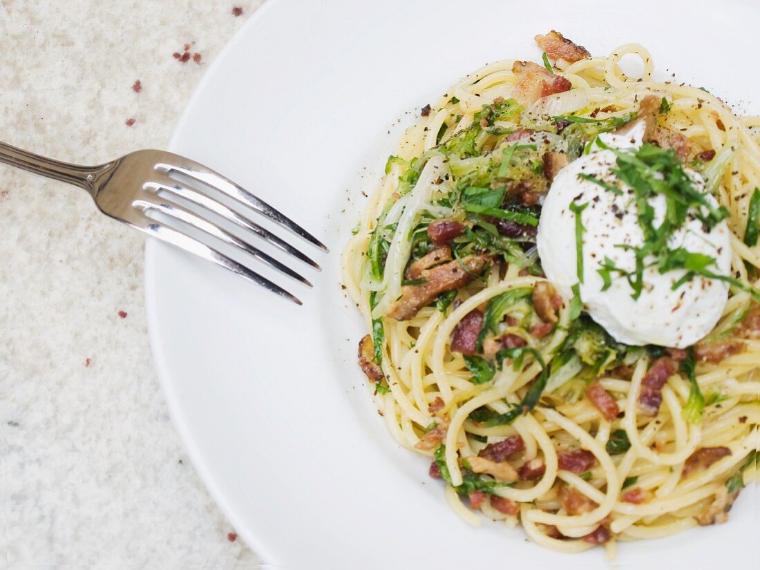 Spaghetti carbonara with a poached egg and herbs