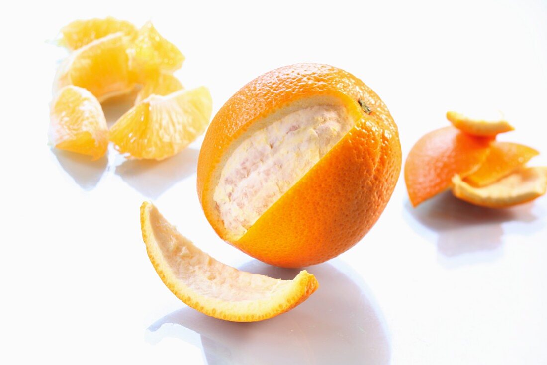 An orange, partially peeled, and orange segments