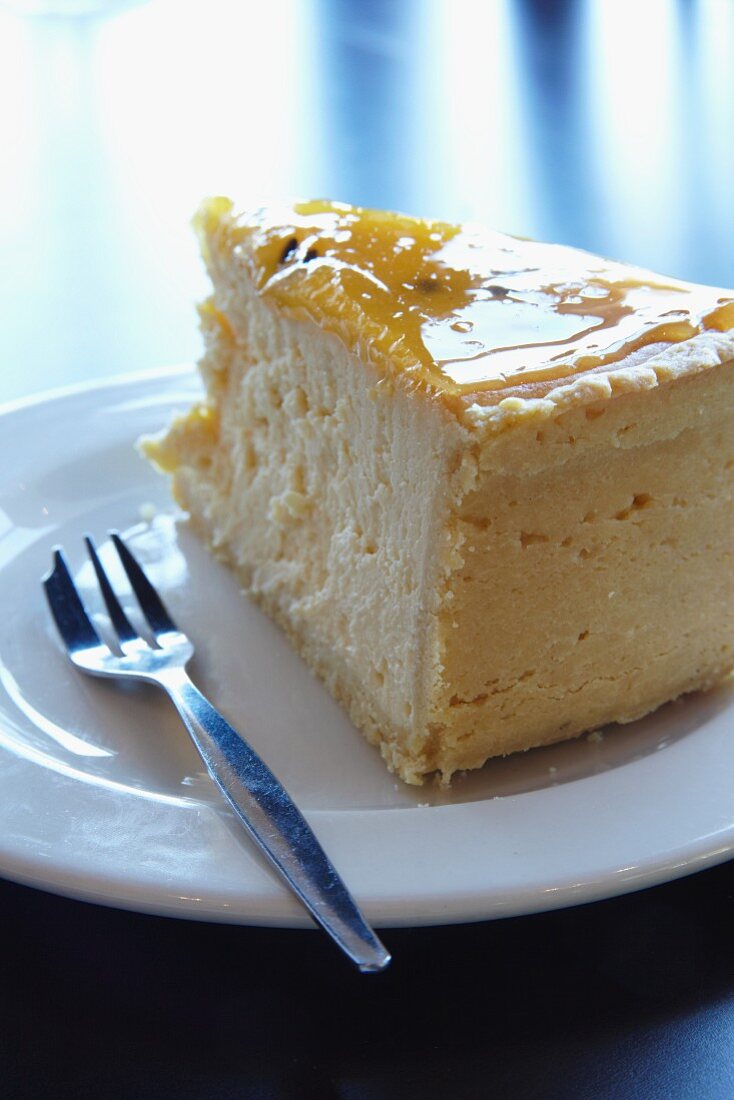 A slice of New York cheesecake with passion fruit glaze