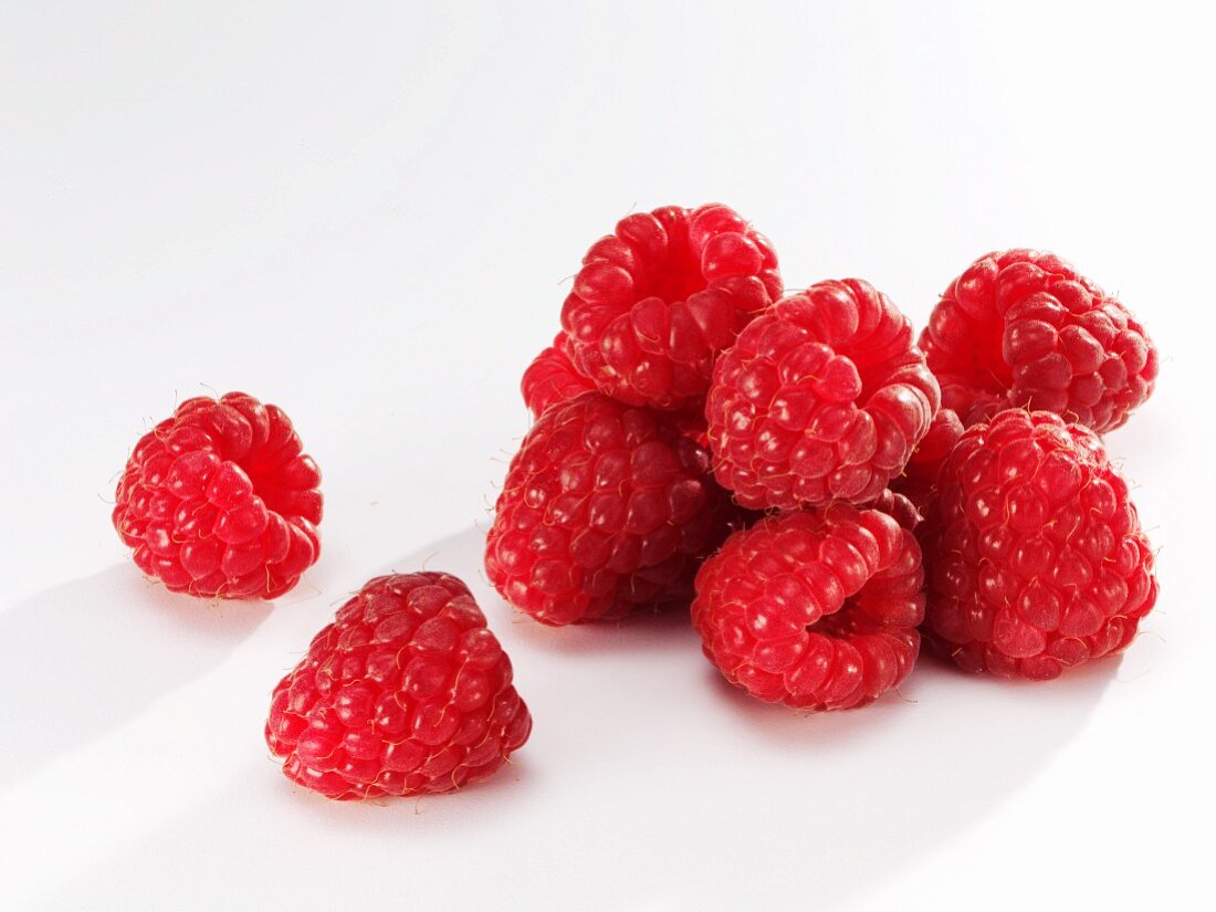 Several raspberries against white background