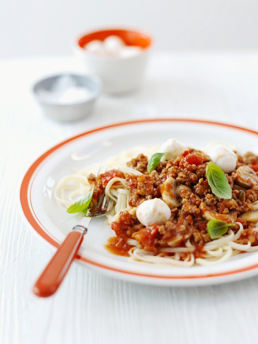 Pasta with a minced meat sauce, mozzarella and basil