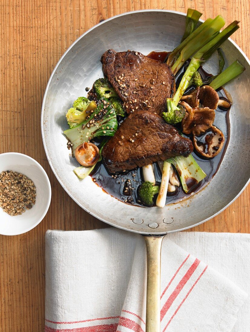 Marinated fillet steaks with stir-fried vegetables and sesame seeds