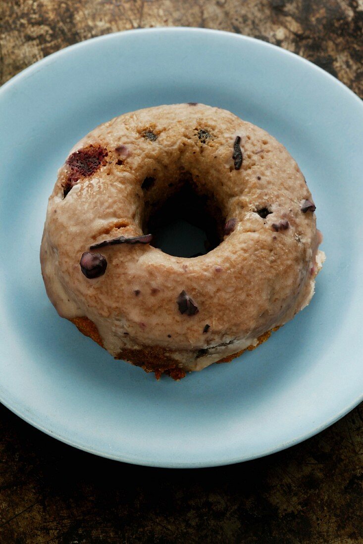 Ein Donut mit Blaubeeren & Earl Grey-Tee auf Teller