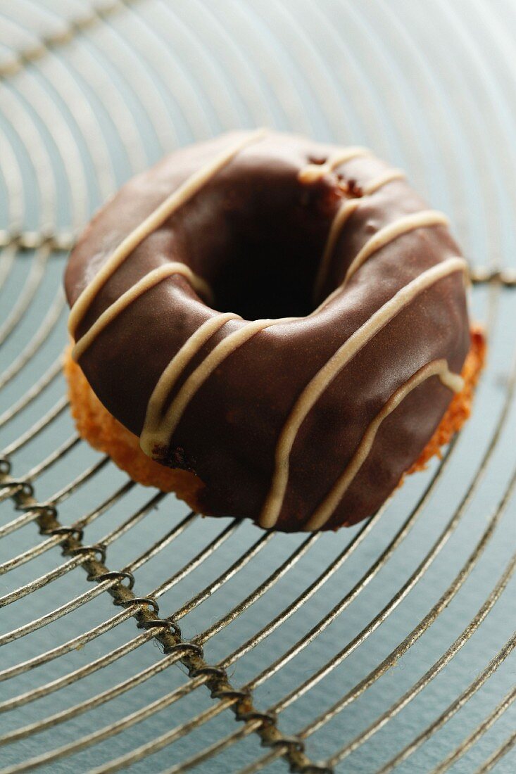 Ein Mini-Donut mit Schokoladenglasur auf Kuchengitter