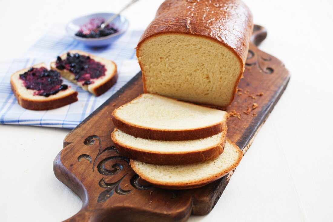 Kastenförmiges Brioche-Brot, eine Scheibe mit Marmelade
